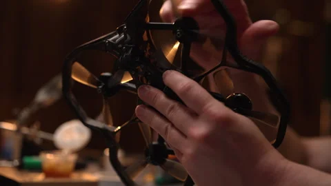 Close-up hands of unrecognizable repairman assembling small fpv drone quadcopter 動画素材 302567422
