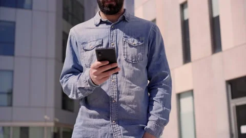 Close up of hands of unrecognizable young businessman in denim shirt using sm Stock Footage 153251206