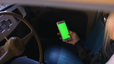 Close up hands use smartphone in vintage car on parking green screen chroma 5g Stock Footage 112137316