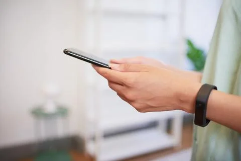 Close up of hands using cellphone, nurse in scrubs with fitness watch Stock Photos
