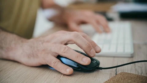Close-up of hands using computer mouse and keyboard at desk for office work and Stock Footage 333723172