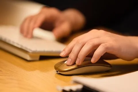 Close-up of hands using computer mouse and keyboard Foto stock