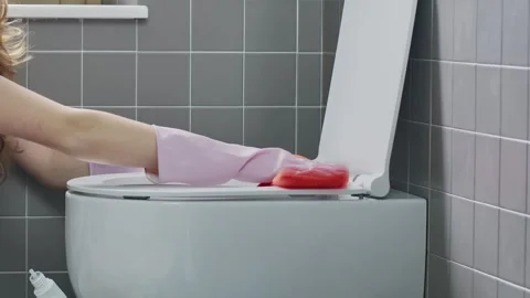 Close Up Hands using a detergent disinfectant bottle and Wiping Toilet Seat Stock Footage 344763740