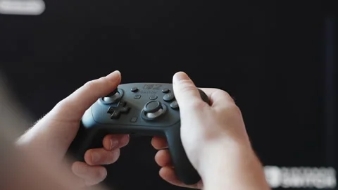 Close Up of Hands Using Game Controller in Front of Screen During Gameplay Stock Footage 345692230
