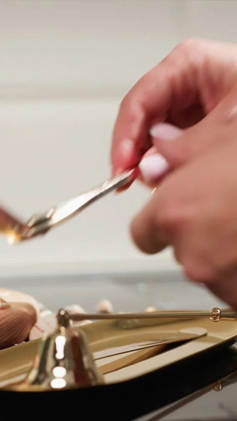 Close up hands using golden tongs to craft layered starfish accent candles with Stock Footage 344682875