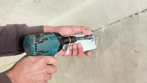 Close-Up of Hands Using Green Impact Driver to Secure a Bolt Fastener Stock Footage 301478386