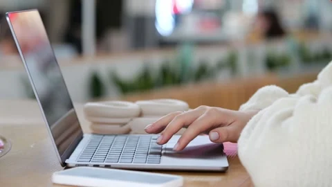 Close-up of hands using laptop in cafe setting Stock Footage 345865115