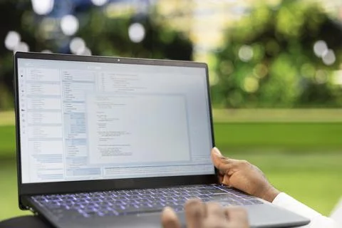 Close up of hands using laptop with source code and programming interface Stock Photos