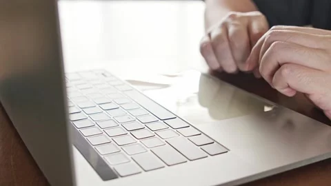 Close-up of hands using a laptop track pad, symbolizing remote work Видео 314770792