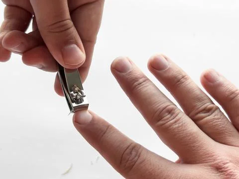 Close up of hands using nail clippers for precise manicure grooming Stock Photos