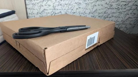 Close Up Of Hands Using Scissors To Open White Shipping Bag Stock Photos