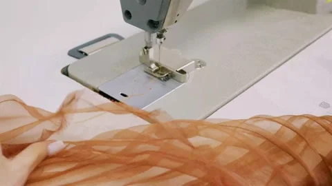 Close up hands using sewing machine to cut off excess thread from brown fab.. Vídeo Stock 339755134