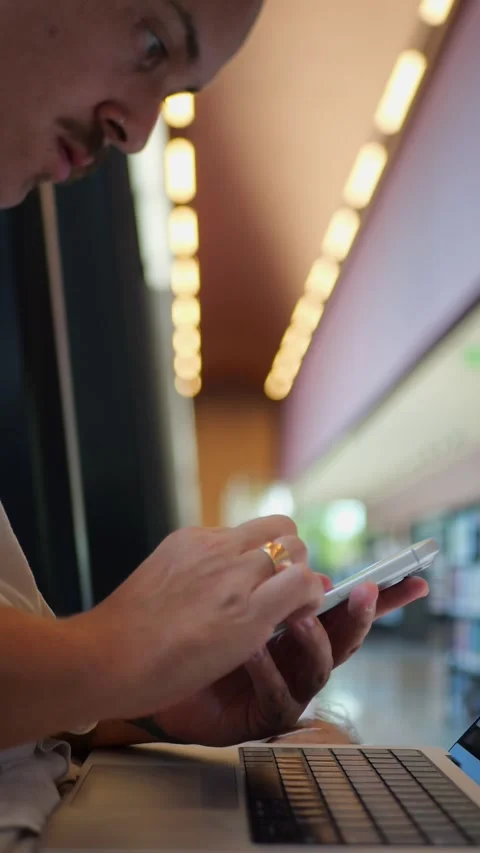 Close-Up of Hands Using Smartphone Alongside Laptop... Vídeo Stock 334437347