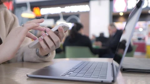 Close-up on hands using smartphone beside open laptop Stock Footage 341185007
