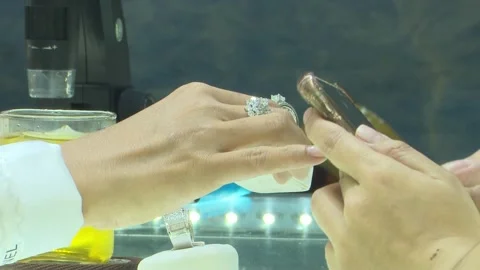 Close Up Hands Using Smartphone Near Diamond Ring On Counter Stock Footage 345502849