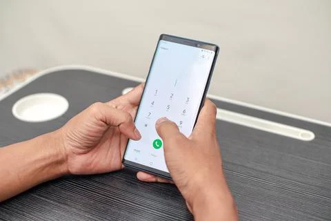 Close Up Of Hands Using A Smartphone With A White Screen And Green Button Stock Photos