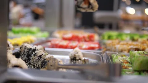 Close-up of hands using a specialized food gripper to carefully select sushi at Video stock 314641485