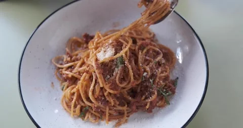 Close up of hands using spoon and fork to roll and eat spaghetti Bolognese Video stock 156796442