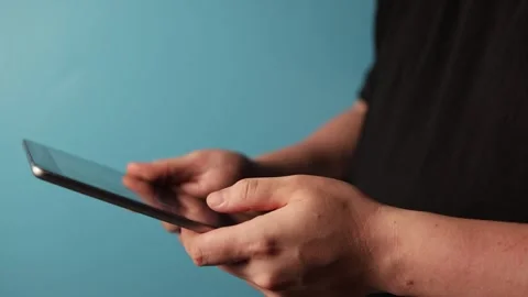 Close-up of hands using a tablet computer on a blue background Stock Footage 340268648