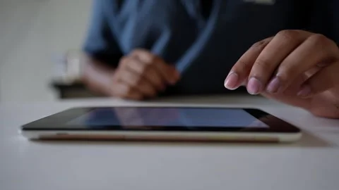 Close-up of Hands Using a Tablet on a Table, Person using a tablet on a whi.. Stock Footage 317737021