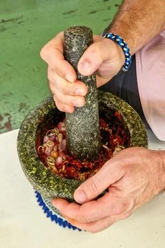 Close-up of hands using a traditional stone mortar and pestle Stock Photos