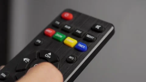 Close up of hands using tv remote 库存影片 276636384