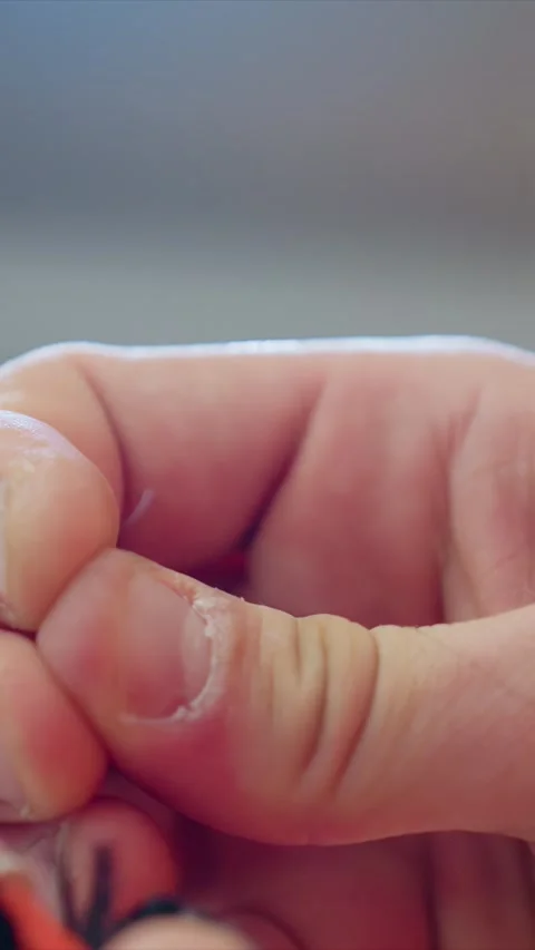 Close up of hands using tweezers to manipulate thin thread with precise manual Stock Footage 348037716
