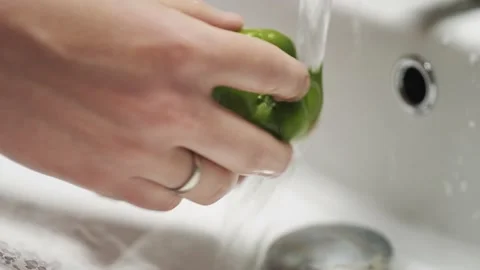 Close-up of hands wash the green pepper under running water. Stock Footage 132082467