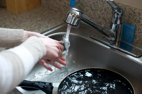 Close up of hands washing silverware Stock Photos