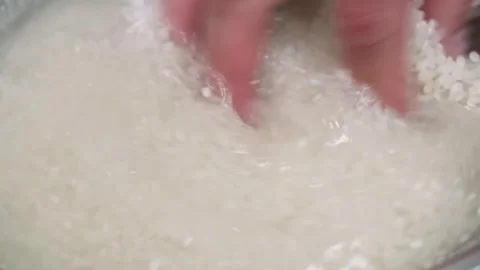 Close-up of Hands Washing White Rice in Water Stock Footage 333497477