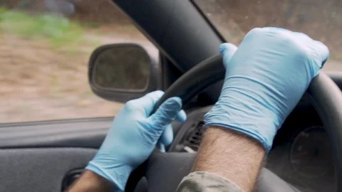 Close up of hands wearing blue protective gloves holding steering wheel Stock Footage 128176565