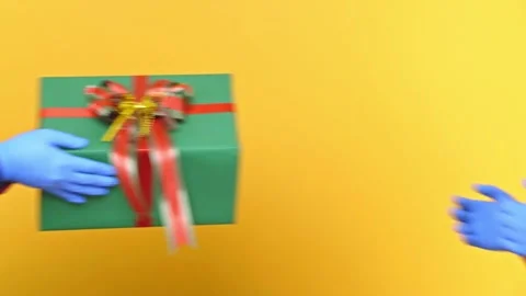 Close up hands wearing medical rubber glove giving the present gift box in chris Stock Footage 145130853