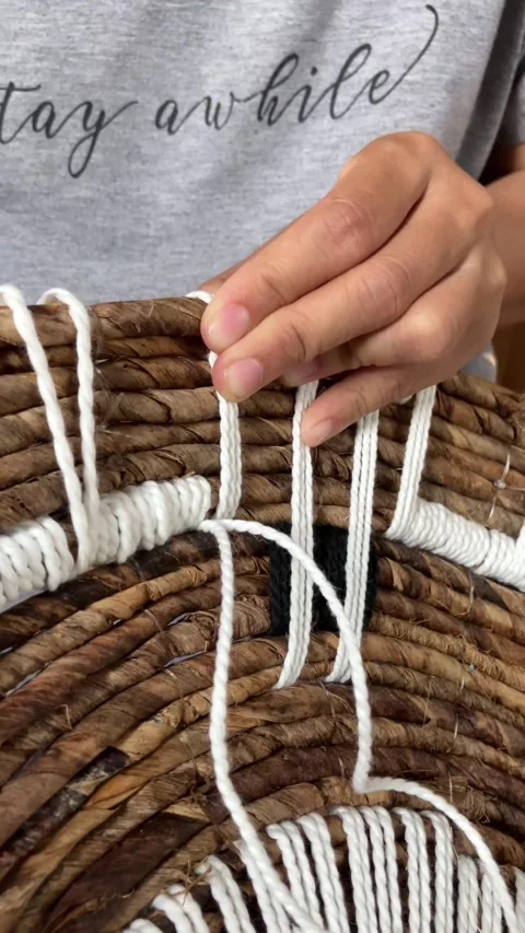 Close-up of hands weaving white macrame cord on wall decor. Stock Footage 345726466