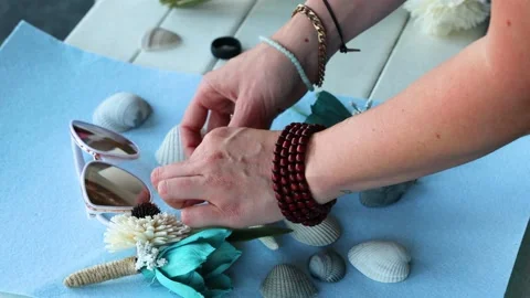 Close up hands of the wedding decorator collect a composition of sea shells and  Stock Footage 136085652