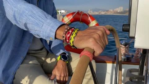Close-Up of Hands on wheel steering sailing yacht in a sunny day. Stock Footage 168287769
