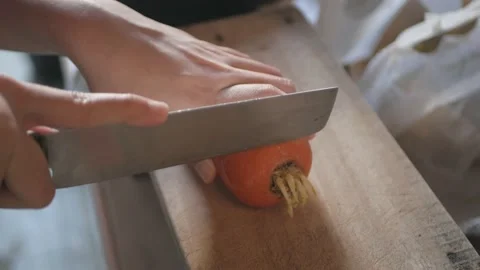 Close up of hands while peeling fresh juicy carrot by peeler Stock Footage 206765687