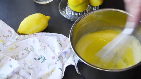Close-up of hands whisking lemon curd in a saucepan Stock Footage 344661285