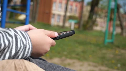 Close-up of hands of a white boy, aged 3-5, using a phone Stock Footage 308479734