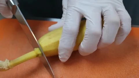 Close-up of Hands in White Gloves Peeling a Fresh Yellow Banana Stock Footage 345651933
