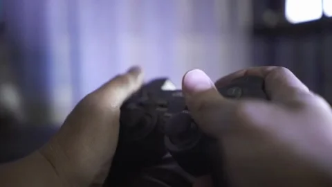 Close-up of hands with a wireless gaming joystick on the console at night. light Stockbeeldmateriaal 334653297
