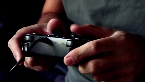 Close-up of hands with a wireless gaming joystick on the console at night. light Stock-Footage 334653419