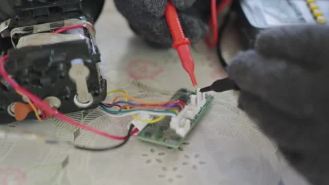 Close-up, hands of woman are using a multimeter to check the vacuum cleaner's 스톡 동영상 332696327
