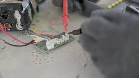 Close-up, hands of woman are using a multimeter to check the vacuum cleaner's 스톡 동영상 332696491