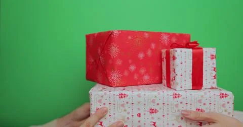 Close-up hands of woman giving stack of gift boxes with Christmas present to man 스톡 사진