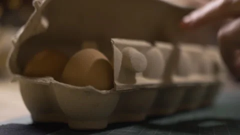 Close-up of hands woman taking egg out of carton and painting it for Easter Stock Footage 329068375