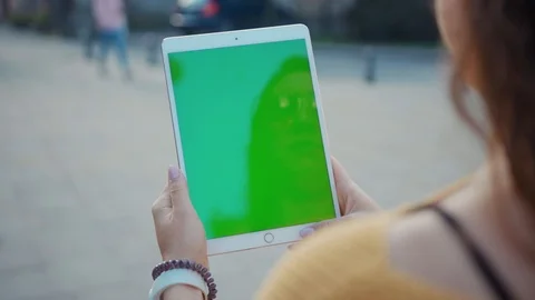 Close up hands woman using tablet device computer with green screen outdoors in Stock Footage 116440976