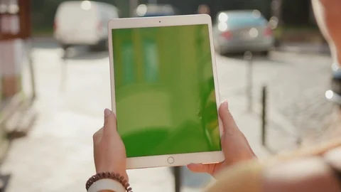 Close up hands woman using tablet device computer with green screen outdoors in Stock Footage 116441243