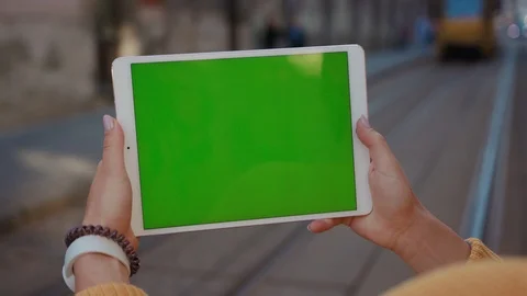 Close up hands woman using tablet device computer with green screen outdoors in Stock Footage 116442197