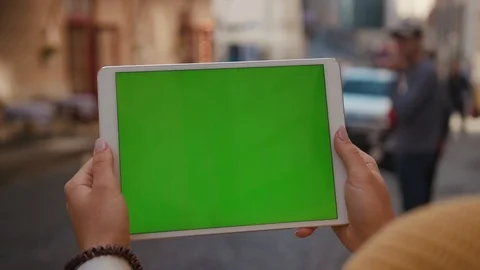 Close up hands woman using tablet device computer with green screen outdoors in Stock Footage 116442911