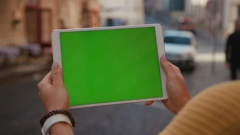 Close up hands woman using tablet device computer with green screen outdoors in Stock Footage 116444507